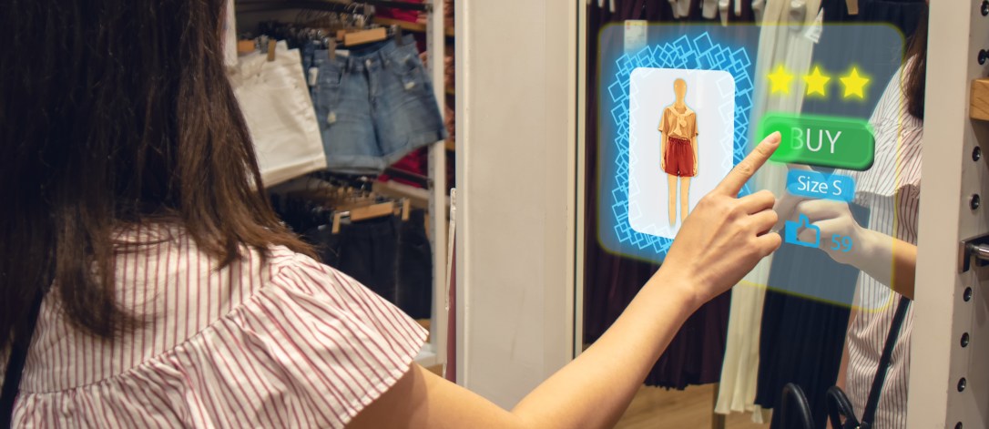iot smart retail futuristic technology concept, happy girl try to use smart display with virtual or augmented reality in the shop or retail to choose select ,buy cloths and give a rating of products