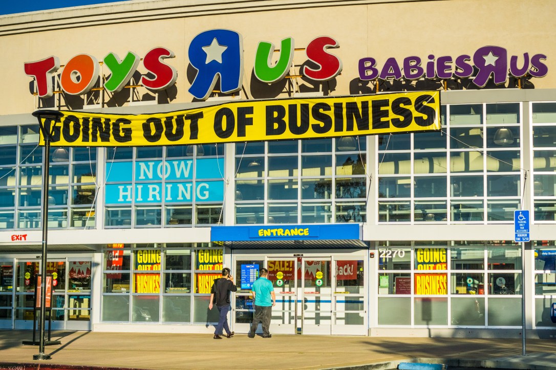 April 20, 2018 San Mateo / CA / USA - Toys R Us logo and "Going out of business" announcement above the entrance to one of the locations in San Francisco bay area; customers going into the store